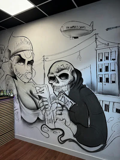 Schwarzweißes Wand-Mural im Chicano-Stil: ein Heiliger mit Aviator-Brille und ein vermummter Skull-Charakter, dahinter Stadt-Silhouette und Zeppelin.