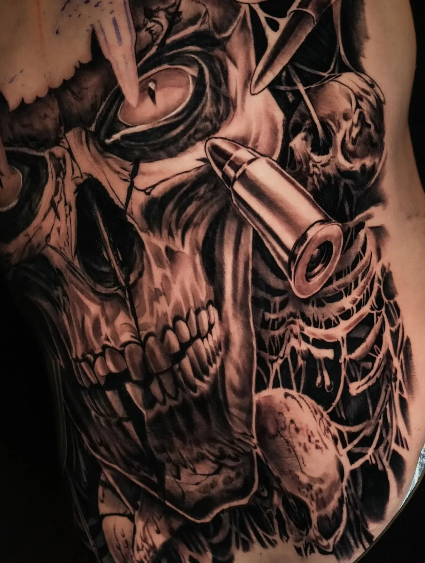 Realistisches Black-&-Grey-Tattoo: detaillierter Skull mit Patrone, Spinnennetz, hochkontraste Schattierungen.
